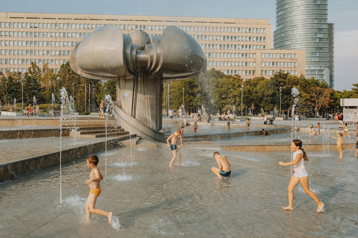 people playing in a fountain in front of a building